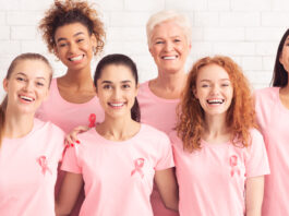 Breast Cancer. Ladies From Oncology Support Group Smiling To Camera Wearing T-Shirts With Pink Ribbon On White Background. Panorama